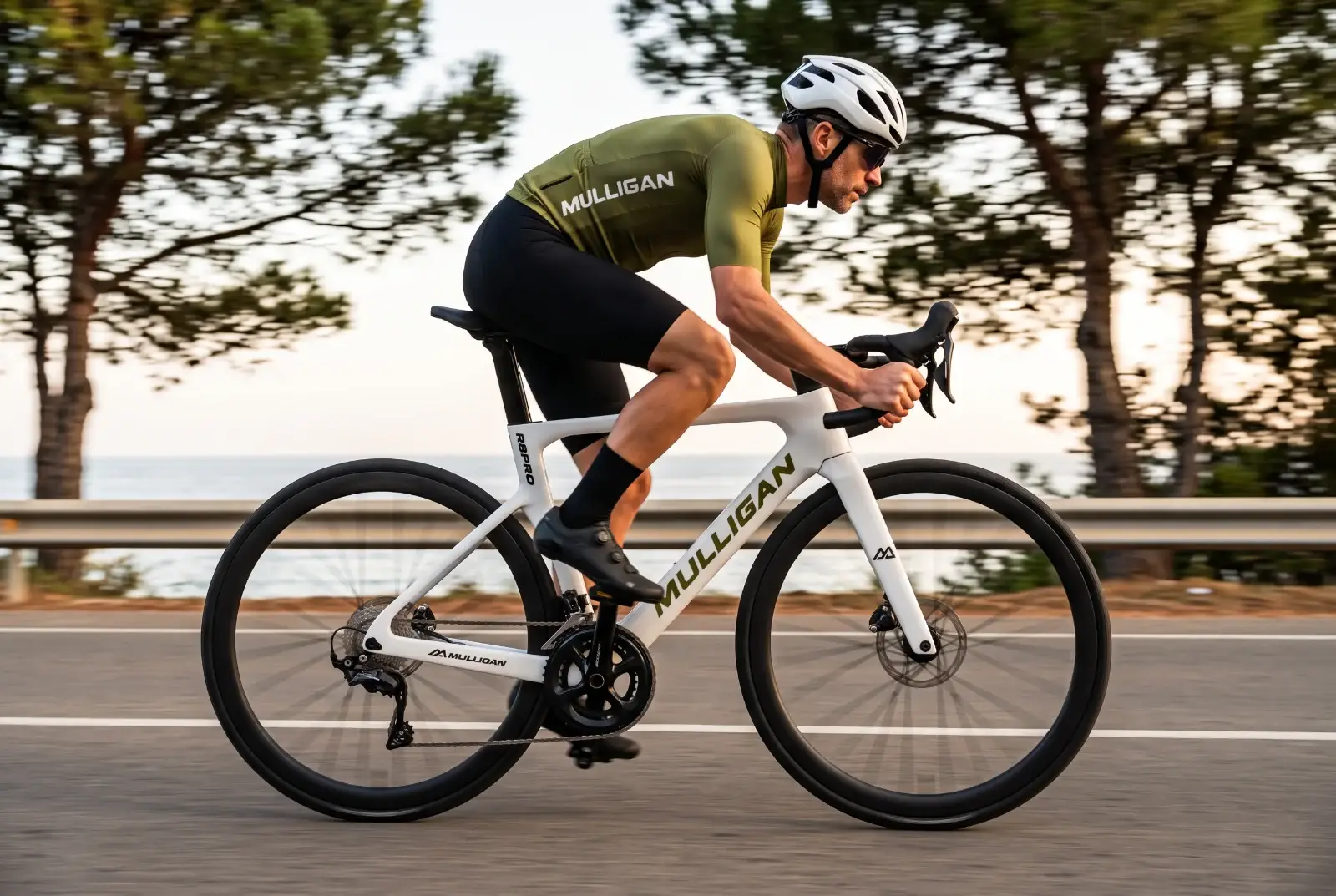 Vélo route carbone MULLIGAN R8PRO blanc à cockpit intégré sur une route côtière