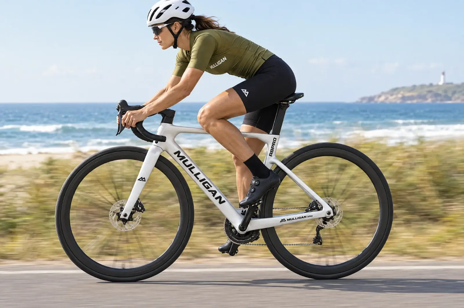 Cycliste sur vélo route carbone MULLIGAN R8PRO blanc en bord de mer, montage WheelTop sans fil en option